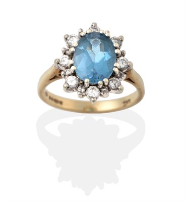 Lot 2042 - A 9 Carat Gold Blue Topaz and Diamond Cluster Ring, the oval cut blue topaz in a white double...