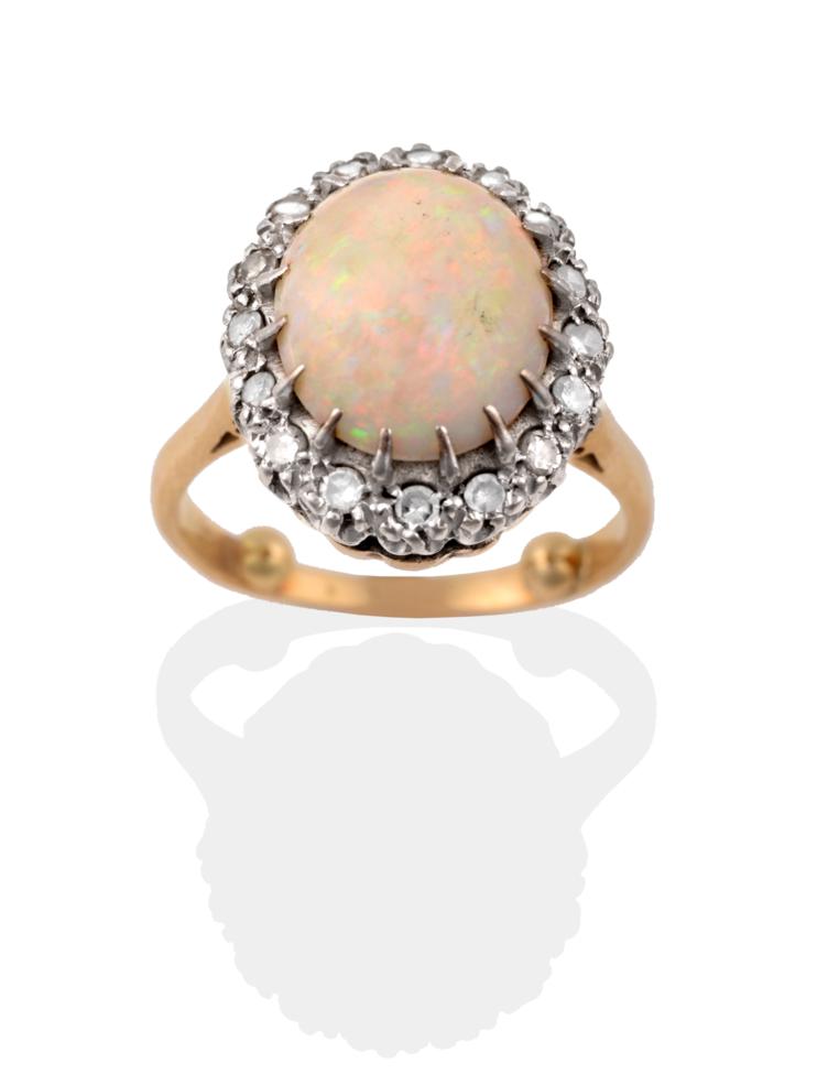 Lot 2059 - An Opal and Diamond Cluster Ring, the oval cabochon opal within a border of eight-cut diamonds...