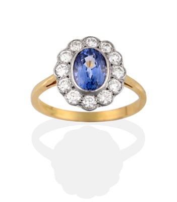 Lot 2063 - A Sapphire and Diamond Cluster Ring, the oval cut sapphire within a border of twelve round...