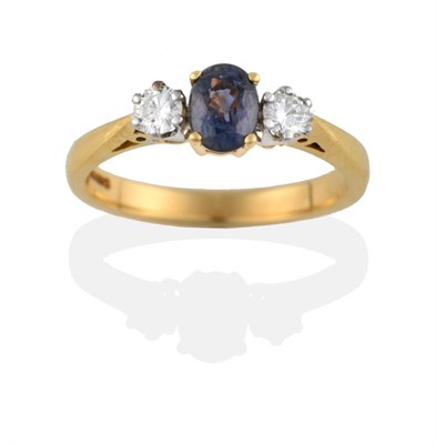 Lot 2074 - An 18 Carat Gold Sapphire and Diamond Three Stone Ring, the oval cut green sapphire between two...