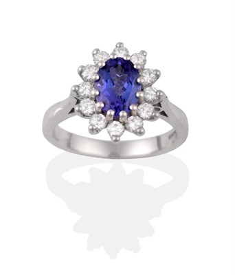 Lot 2111 - An 18 Carat White Gold Tanzanite and Diamond Cluster Ring, the oval cut tanzanite within a...