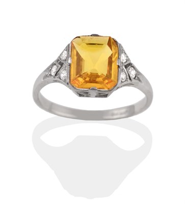 Lot 2115 - A Yellow Sapphire and Diamond Ring, in the Art Deco Style, the emerald-cut yellow sapphire in white