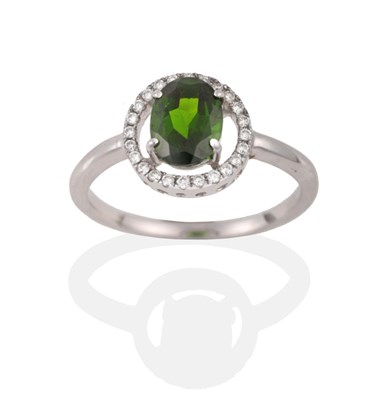 Lot 2119 - A Green Garnet and Diamond Cluster Ring, the oval cut green garnet within a halo of round brilliant