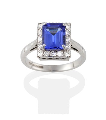 Lot 2123 - An 18 Carat White Gold Tanzanite and Diamond Cluster Ring, the emerald-cut tanzanite in a four claw