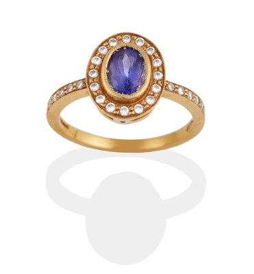 Lot 2137 - An 18 Carat Gold Tanzanite and Diamond Cluster Ring, an oval cut tanzanite within a border of round