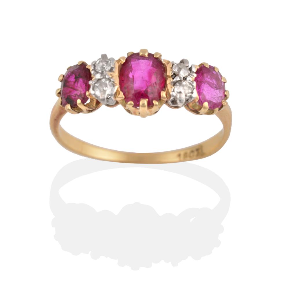 Lot 2144 - A Ruby and Diamond Ring, three oval cut rubies spaced by pairs of eight-cut diamonds, in yellow and