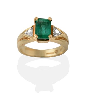 Lot 2154 - A 14 Carat Gold Emerald and Diamond Ring, the step-cut emerald in a yellow claw setting, flanked by