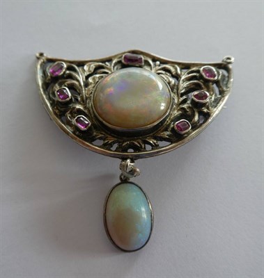 Lot 2159 - An Arts & Crafts Style Opal and Ruby Brooch, the shield motif set centrally with a circular...