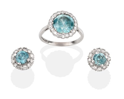 Lot 2163 - A Blue Zircon and Diamond Cluster Ring, the round brilliant cut zircon within a border of eight-cut