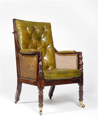 Lot 1565 - A Mahogany and Caned Library Bergere, circa 1825, with back cushion and squab in olive leather,...