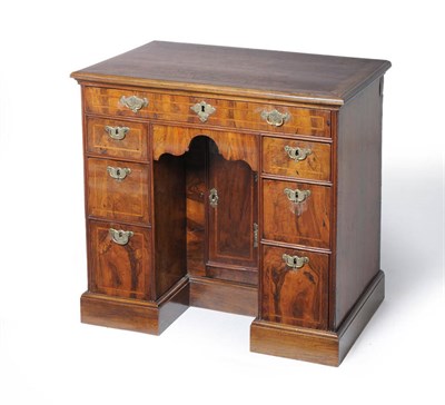 Lot 1587 - A George II Figured Walnut Kneehole Dressing Table, the moulded top above a single frieze...