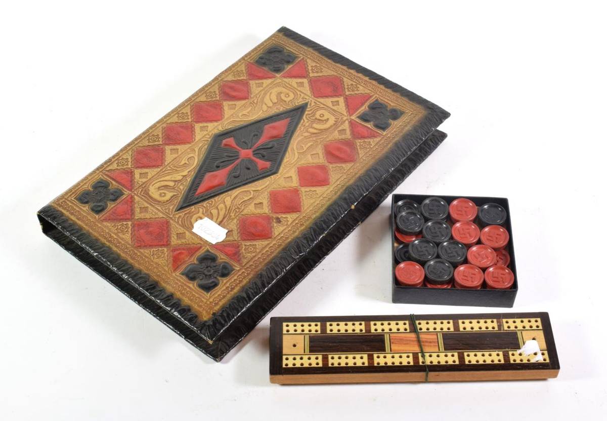 Lot 295 - Third Reich book-form backgammon board, the counters with swastika emblem; and a cribbage board