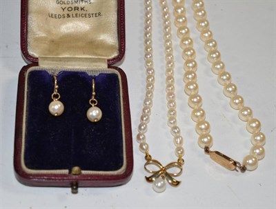 Lot 398 - A cultured pearl necklace with a bow motif pendant, clasp stamped '375'; another cultured pearl...