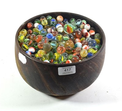 Lot 417 - A treen bowl containing a large collection of marbles