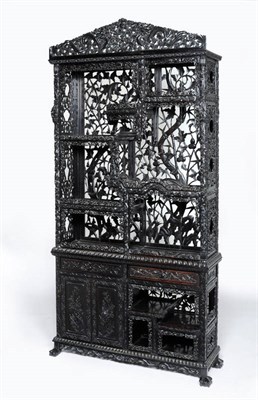 Lot 1633 - A Chinese Carved Hardwood Display Cabinet, circa 1900, the upper section richly carved with a...