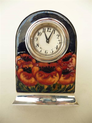 Lot 1656 - A William Moorcroft "Big Poppy" Mantel Clock, on a dark blue ground, mounted with a white metal...