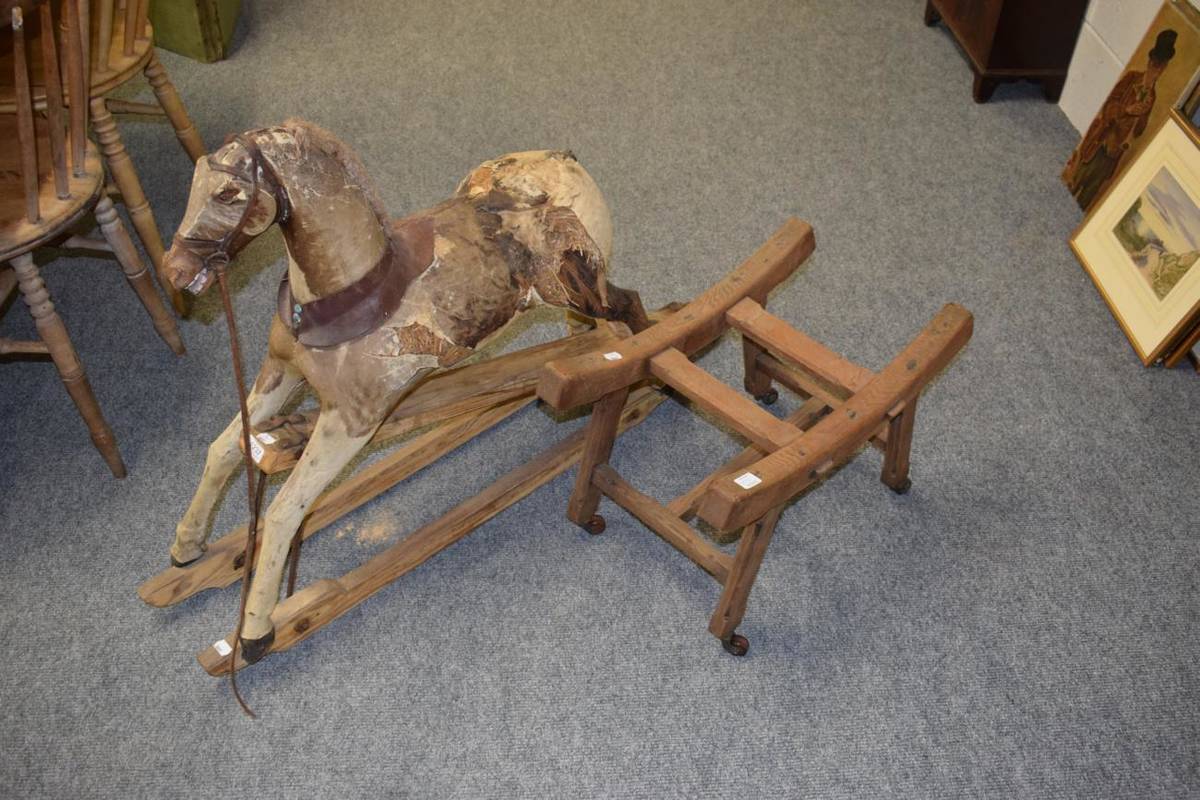 Lot 1237 - Late 19th century hide covered rocking horse with carved wooden head and hooves on a rocker...