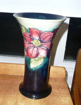 Lot 1662 - A Walter Moorcroft "Clematis" Trumpet Vase, on a blue/green ground, impressed factory mark and...