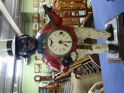 Lot 1250 - ~ A novelty rocking eye mantel timepiece modelled as a banjo player, painted metal