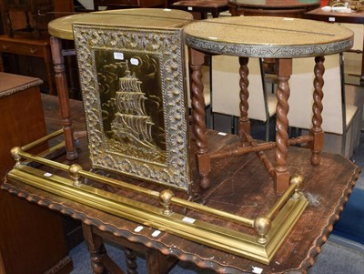 Lot 1275 - Two brass top circular Eastern tables with folding stands; brass firescreen and a brass fire curb