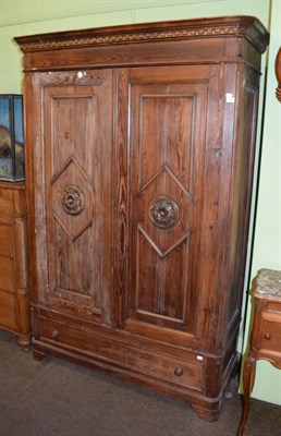 Lot 1311 - A Continental pitch pine armoire fitted with a base drawer