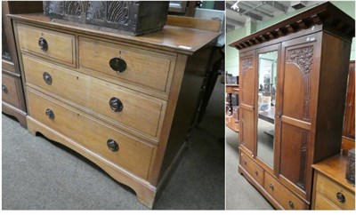 Lot 1326 - An Arts & Crafts carved walnut two piece bedroom suite, comprising a double door wardrobe with...