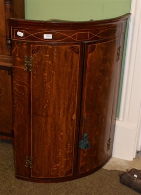 Lot 1384 - George III oak and mahogany cross-banded bow fronted hanging corner cupboard