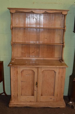 Lot 1391 - A Victorian pine kitchen dresser, the rack with two shelves, the base of two moulded cupboard doors