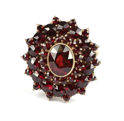 Lot 133 - A Garnet Cluster Ring, with three rows of rose cut garnets, in yellow claws, on a plain...