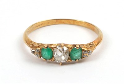 Lot 183 - A Late 19th Century Emerald and Diamond Ring, an old cut diamond sits between two cushion cut...