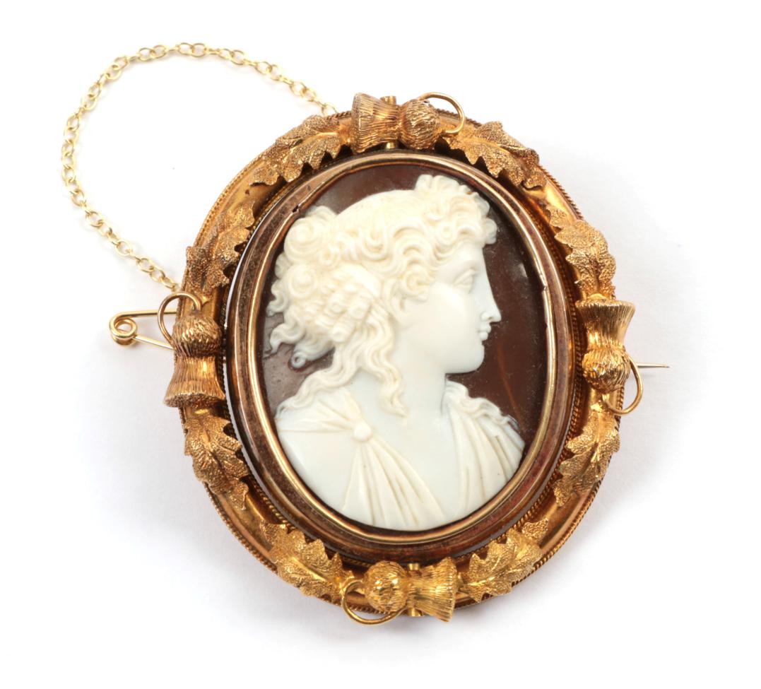 Lot 187 - A Cameo Brooch, the classical figure within a frame with thistle and leaf decoration, with a locket