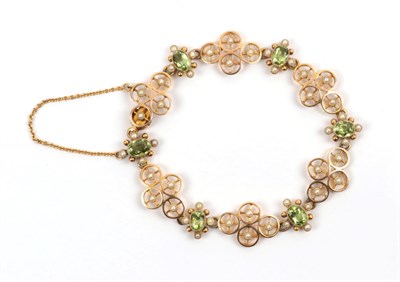 Lot 189 - An Early 20th Century Peridot and Seed Pearl Bracelet, quatrefoil links of circular disks with...