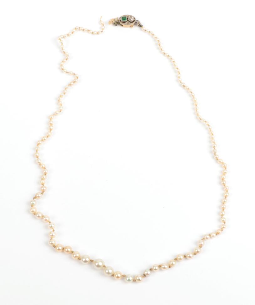 Lot 197 - A Pearl Necklace, graduated pearls knotted to an emerald and diamond snap, length 44.7cm (a.f.)