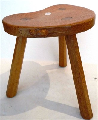 Lot 1762 - A Robert "Mouseman" Thompson Oak Kidney Calf Stool, on three octagonal legs, with carved mouse...