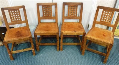 Lot 1768 - A Set of Four Robert "Mouseman" Thompson Oak Lattice Back Dining Chairs, with cow hide studded...