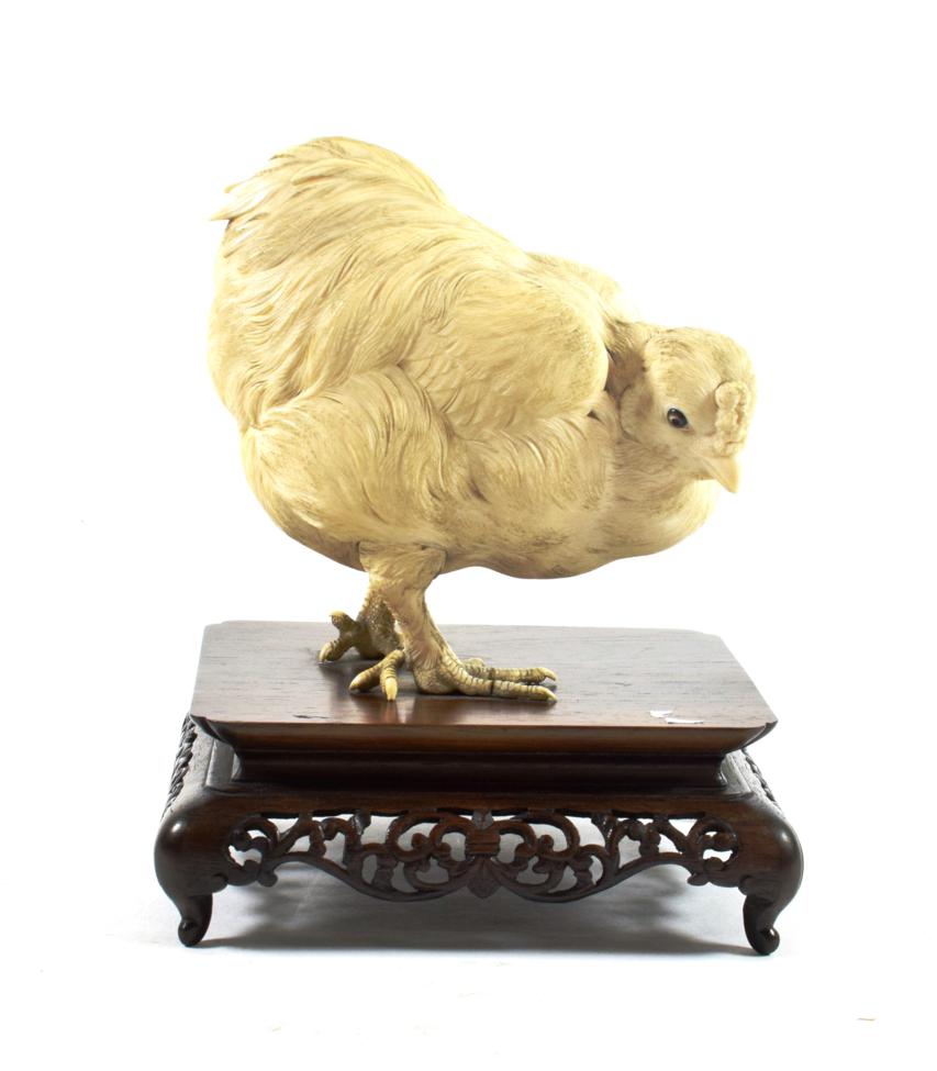 Lot 624 - A Japanese Ivory Model of a Chicken, Meiji period, naturalistically modelled standing on a hardwood