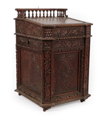 Lot 1643 - A Victorian Oak Davenport, circa 1870, carved overall with leaves, acorns and lozenges, the...