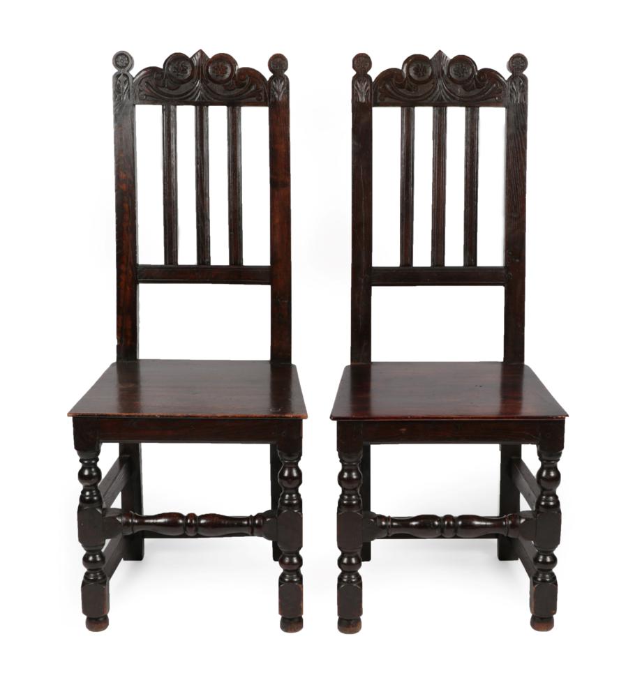 Lot 1667 - A Pair of Joined Oak Side Chairs, the scrolled and carved top rails above reeded splats and...