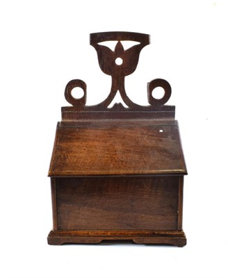 Lot 1672 - A Carved Oak Candle Box, 18th century, with stylised foliate cresting and hinged slope, 25cm wide