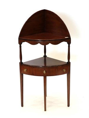 Lot 1736 - A George III Mahogany Corner Washstand, late 18th century, with a wavy shaped apron above...