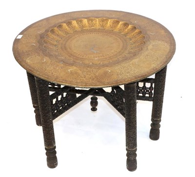 Lot 1787 - An Indian Engraved Brass Top Circular Folding Table, early 20th century, the foliate border...