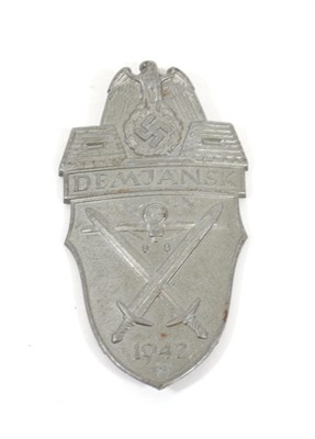 Lot 186 - A German Third Reich Demjansk Shield, in stamped grey zinc, the reverse with four fixing blades set