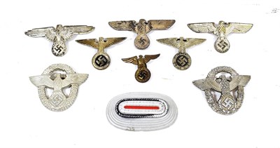 Lot 208 - Nine German Third Reich Metal Cap Badges, comprising two SS white metal and enamel visor cap...