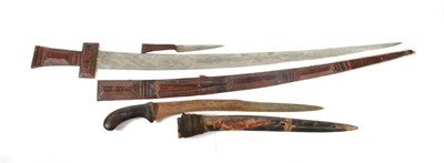 Lot 332 - A Tuareg Takouba (Sword), North Africa, the 79cm double edge steel blade engraved with diapered...