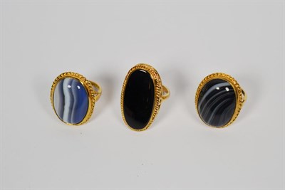 Lot 114 - A 9 carat gold onyx ring, finger size Q1/2, and two 9 carat gold banded agate rings, finger sizes P