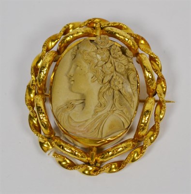 Lot 125 - A lava cameo brooch, carved in high relief with the bust of Flora, in a fancy rope frame, with...