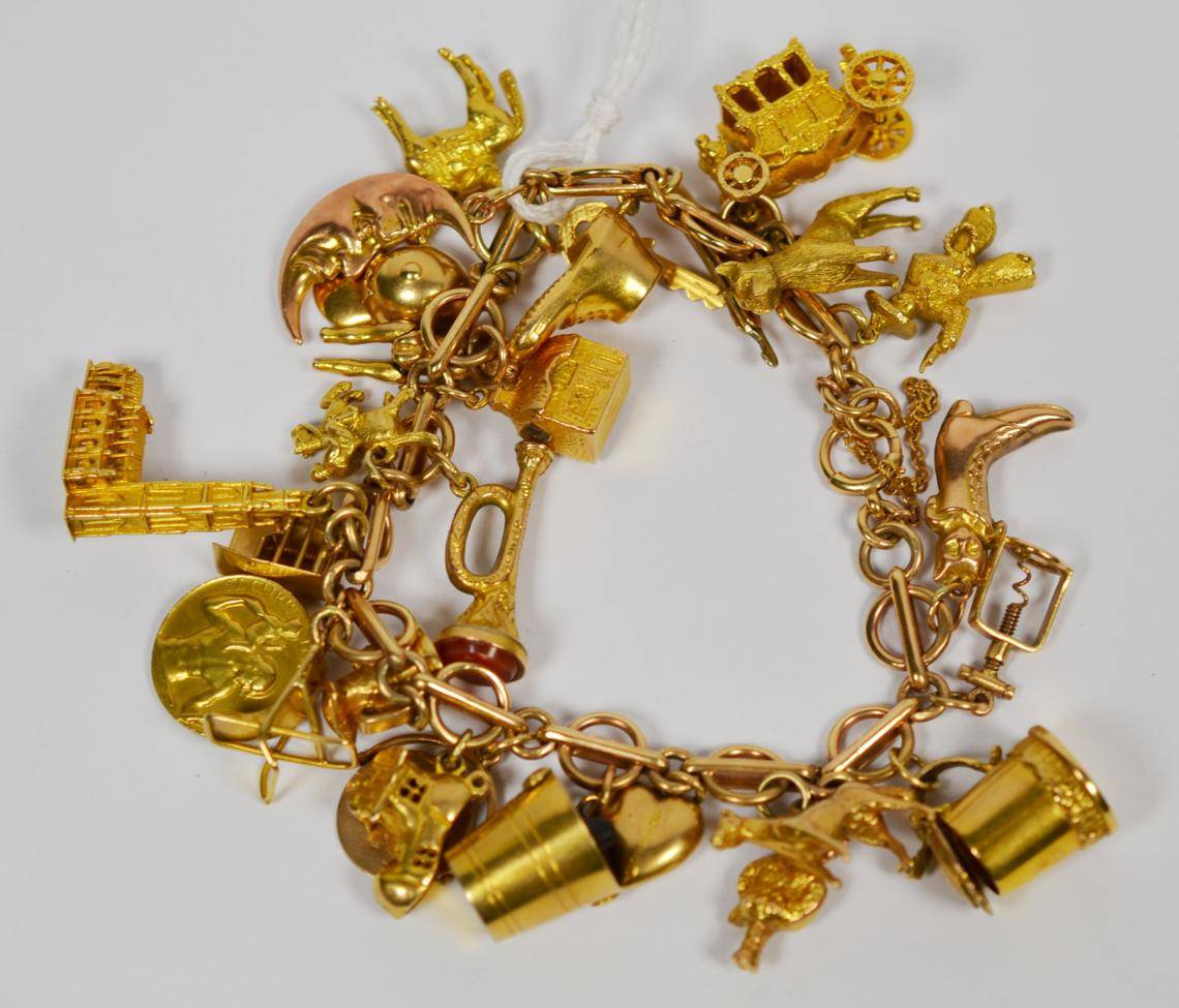 Lot 126 - A charm bracelet, alternate links stamped '9' '.375', hung with twenty six charms and one...