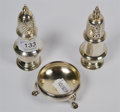 Lot 133 - Two George II silver casters and a George III silver salt-cellar, the casters by Samuel Wood,...