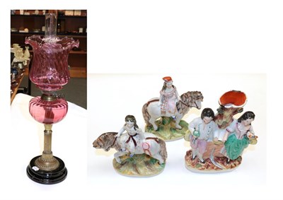 Lot 180 - Victorian oil lamp with cranberry glass font and shade, and three Staffordshire pottery figures (4)