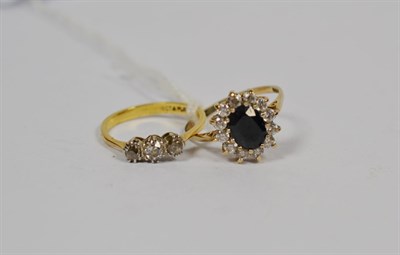 Lot 201 - A three stone diamond ring, stamped '18CT & PLAT', finger size N, and a 9 carat gold sapphire...